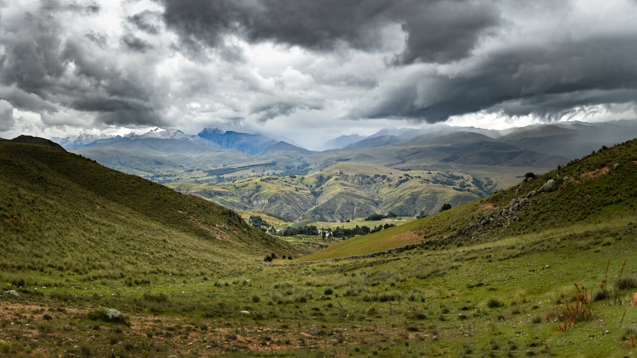 Captivating view of lush valleys and mountains under a stormy sky in the Peruvian Andes.